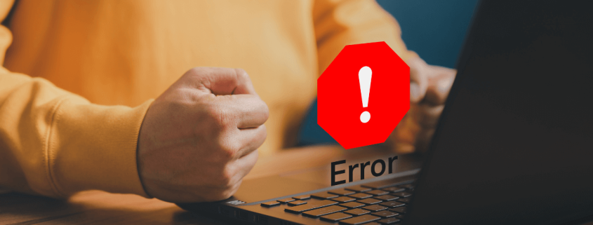 Una persona con el puño apretado en frente de un ordenador y una señal de error, mantenimiento preventivo y correctivo