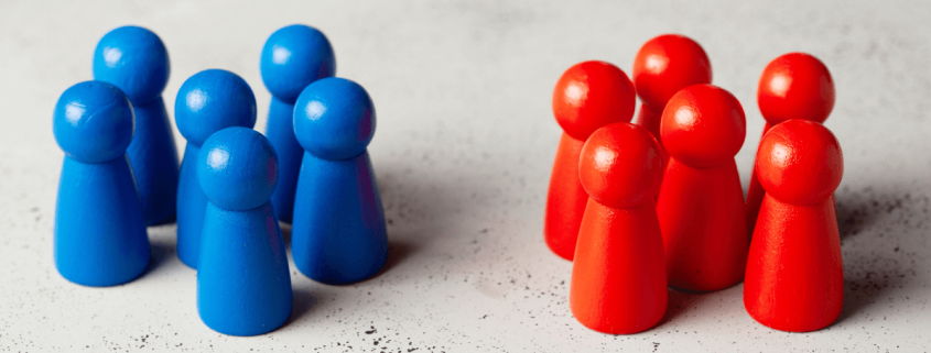 Muñecos de madera de color rojo y azul, representando equipos de ciberseguridad, Blue y Red Team