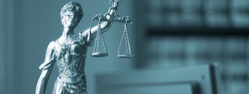 Representación de la justicia con balanza y espada en una oficina legal, símbolo de las obligaciones legales en ciberseguridad para empresas.